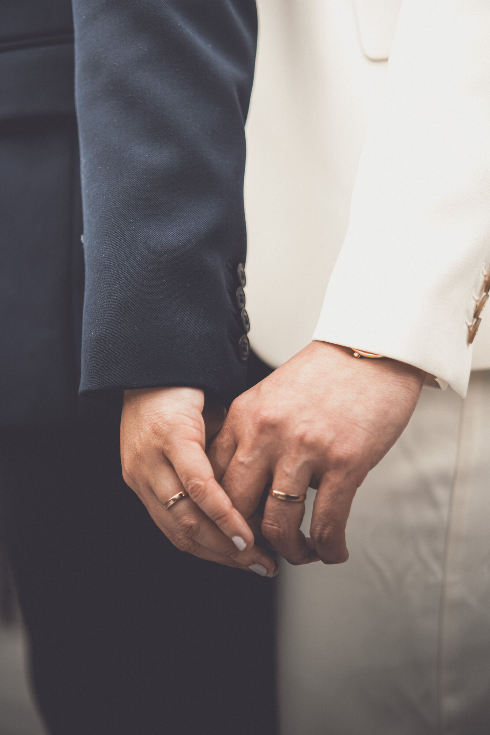 Two hands intertwined with wedding rings — Amanda & Gabi, photographed by Anna Mello